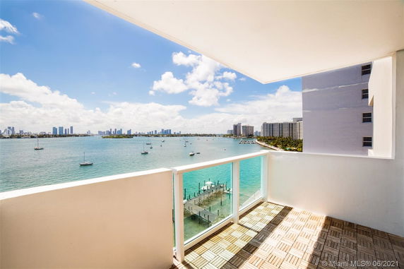 Panoramic view from a balcony overlooking water and distant skyline.