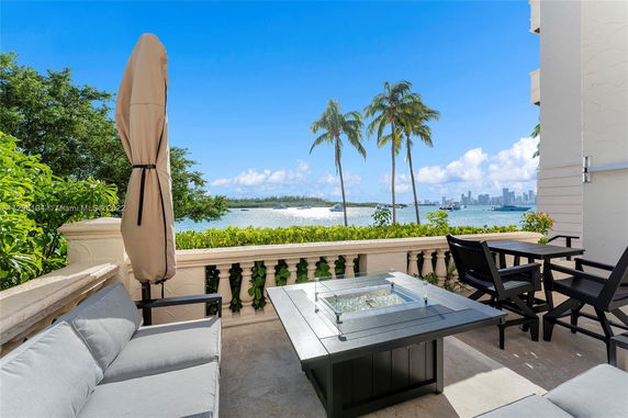 Outdoor patio with a view of the ocean and city skyline in the background.