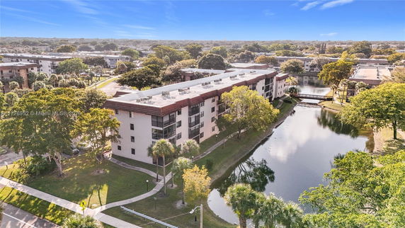 Aerial view of a multi-story residential building near a waterway.