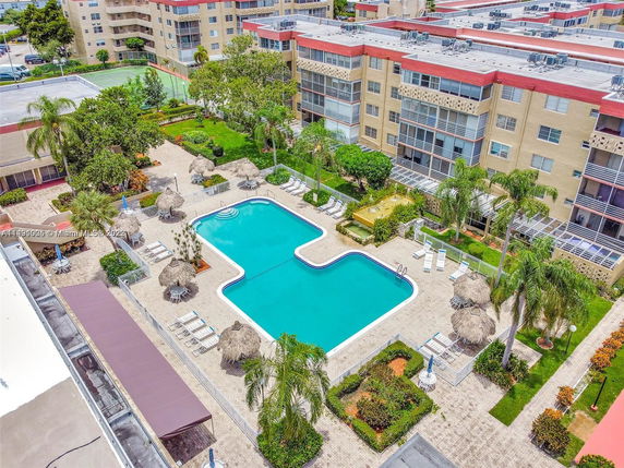 Aerial view of a residential building complex with a swimming pool and surrounding patio areas.