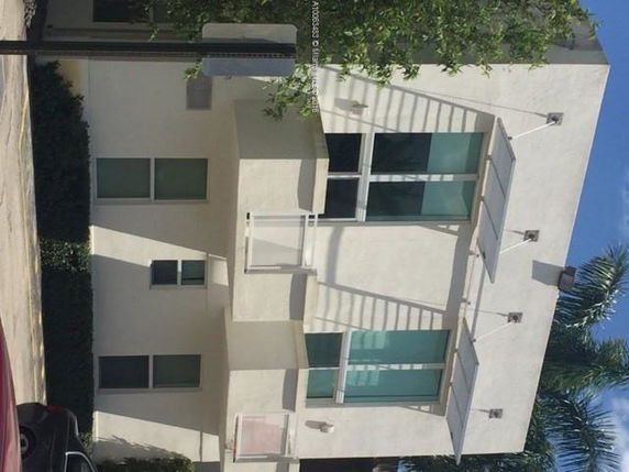 Front view of a modern two-story house with large windows and a flat roof.