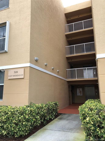Front view of a multi-story building with balconies and a sign reading '509 East Sheridan St.'