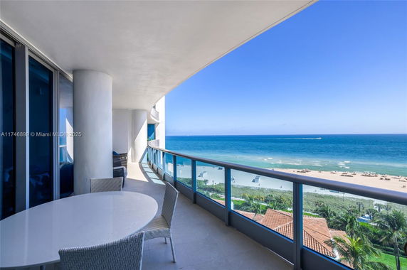 Balcony view overlooking a beach and ocean.
