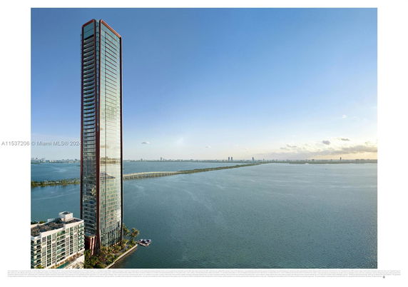 View of a tall skyscraper beside a body of water with distant city landscape.