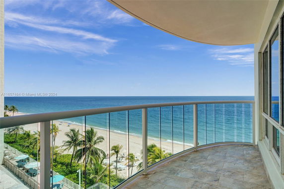 Panoramic view from a balcony overlooking a beach and ocean.