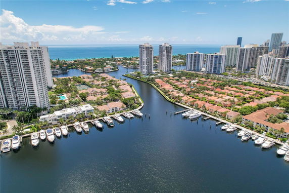 Panoramic view of high-rise buildings overlooking a waterway with boats docked along the shore.