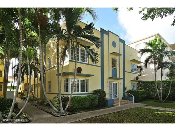 Front view of a two-story building with yellow walls and blue accents.