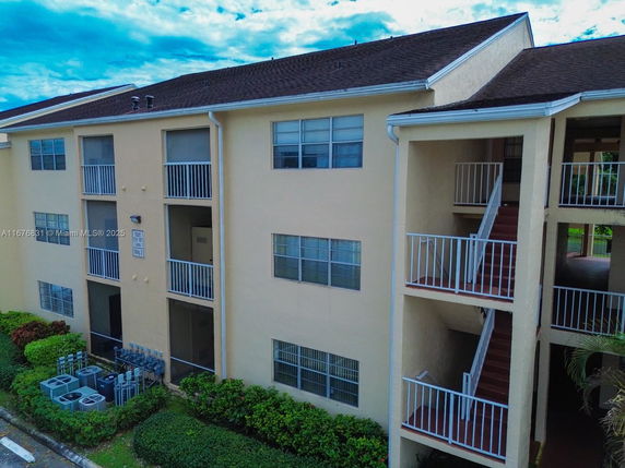 Front view of a multi-story residential building with balconies and a stairwell.