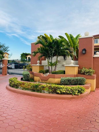 Front view of a building with decorative landscaping and potted plants.