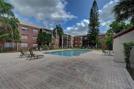 Outdoor swimming pool area with surrounding apartment buildings.