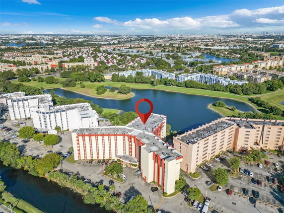 Aerial view of multiple apartment buildings near a body of water in an urban area.
