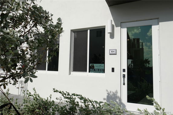 Front view of a modern house unit with a glass door and windows.