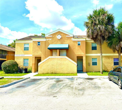 Front view of a two-story building with a central entrance and a yellow facade.