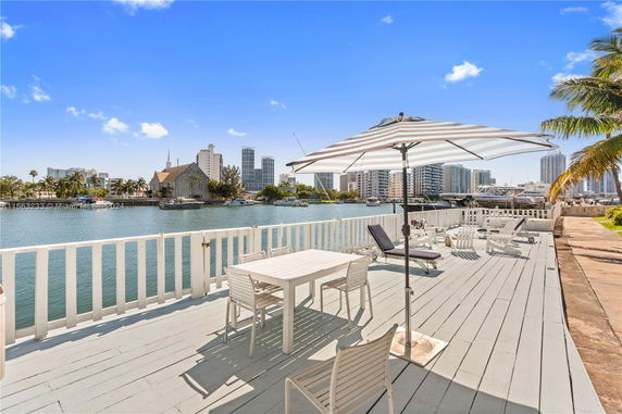 Outdoor deck area overlooking a waterway with city buildings in the background.