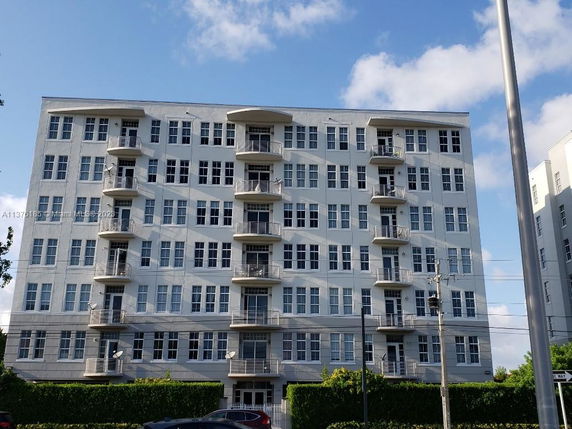 Front view of a multi-story apartment building with balconies.