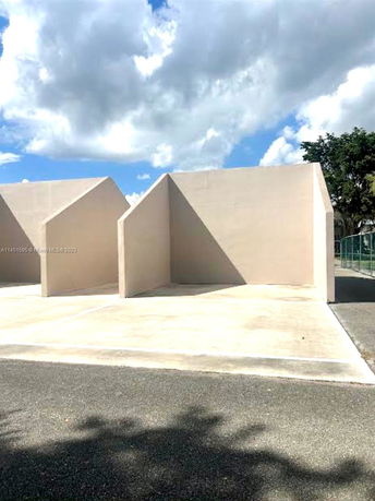 Outdoor parking area with minimalist wall partitions.