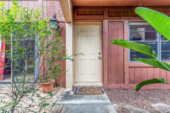 Front view of a house with a wooden facade and entrance door.