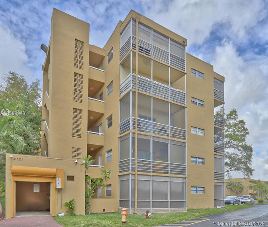 Front view of a multi-story apartment building with balconies.