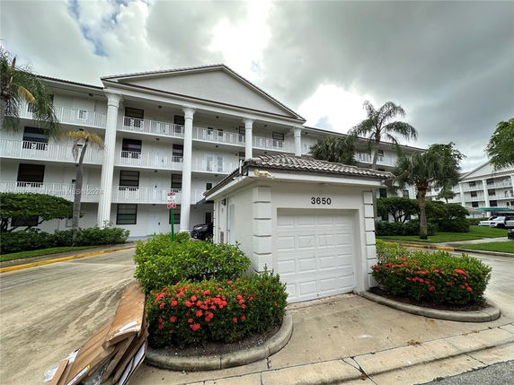 Front view of a multi-story building with a small garage in the foreground.