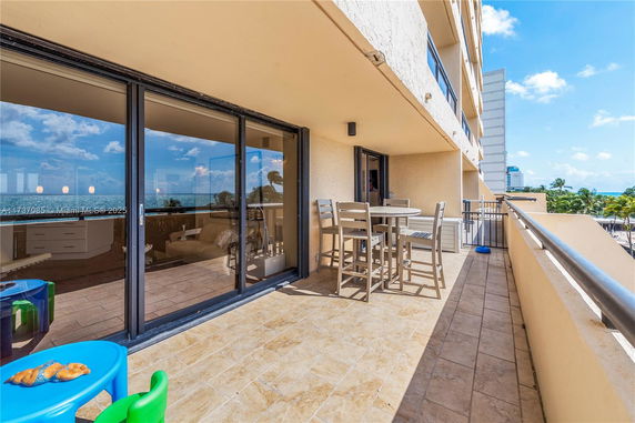 Balcony area with sliding glass doors and a view of the ocean.