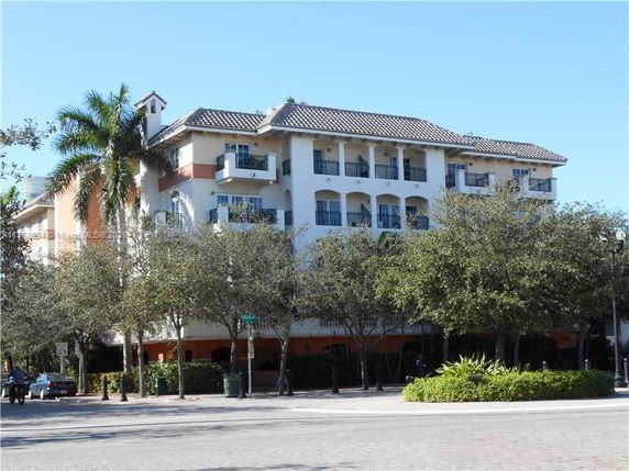 Front view of a multi-story building with balconies and a tile roof.