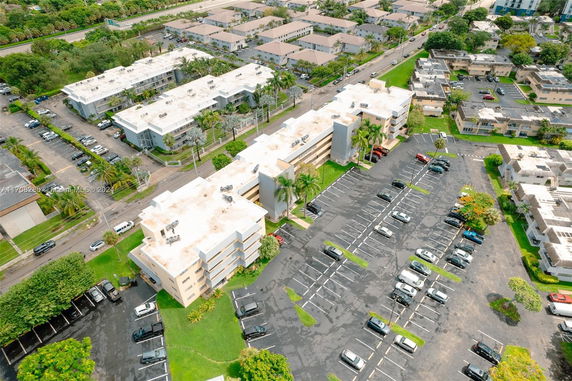 Aerial view of multiple apartment buildings and parking lots in a residential area.