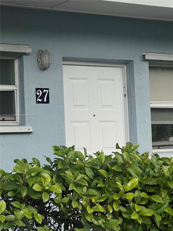 Front view of a house entrance with door number 27 above the door.