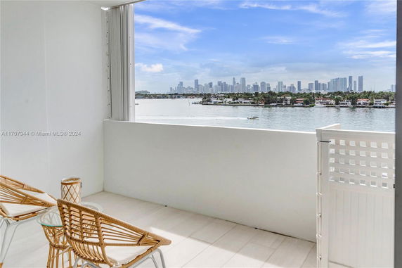 View from a balcony overlooking water and a distant city skyline.