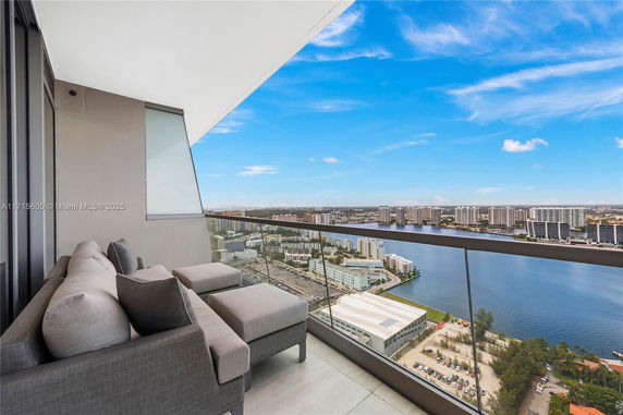 Panoramic view from a balcony overlooking a body of water and city skyline.