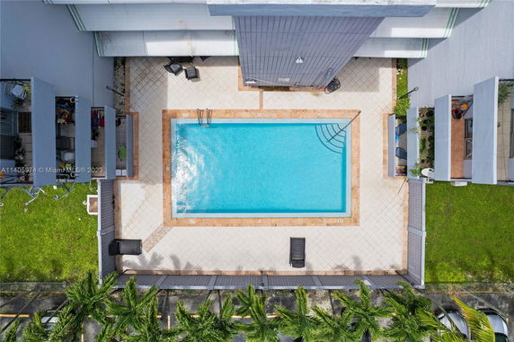 Overhead view of a rectangular swimming pool surrounded by a tiled deck.