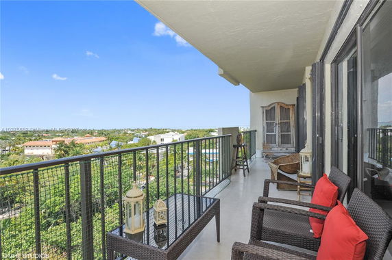 Balcony view from an apartment overlooking residential and greenery areas.