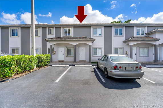 Front view of a two-story townhouse with parking area.