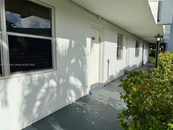Front view of a building with a covered entrance walkway and windows.