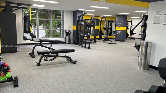 Indoor gym area with exercise equipment and weight benches.