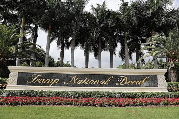 Sign for Trump National Doral with palm trees and landscaping in the background.