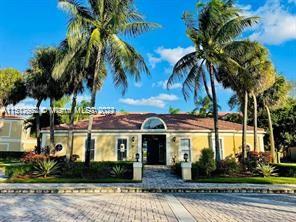 Front view of a single-story house with palm trees.