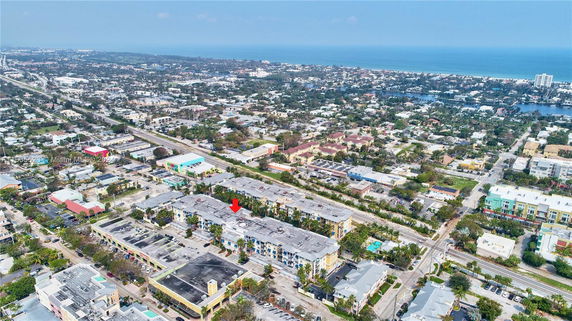 Aerial panoramic view of a town with many buildings, roads, and nearby coastline.