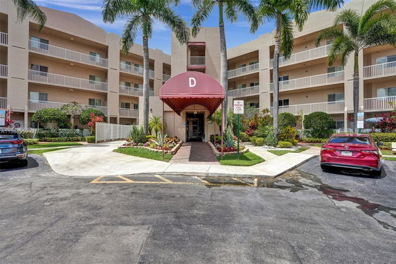 Front view of a multi-story residential building with a marked entrance area.