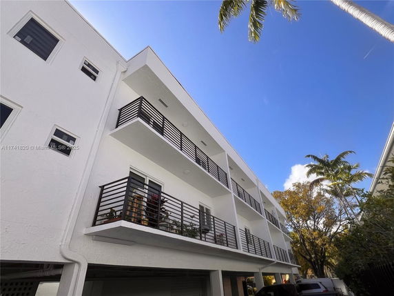 Front view of a multi-story building with balconies and a modern design.