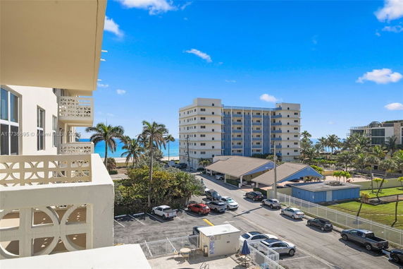 View of surrounding buildings and ocean from a higher level of a building.