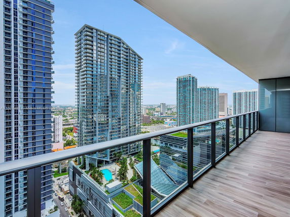 Panoramic view from a high-rise balcony overlooking multiple modern skyscrapers.