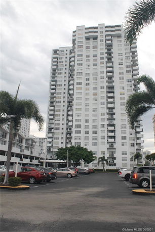 Front view of a high-rise apartment building with multiple balconies.