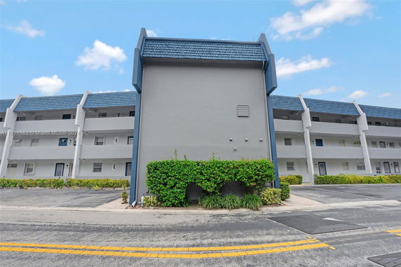 Front view of a multi-story residential building with a blue roof.