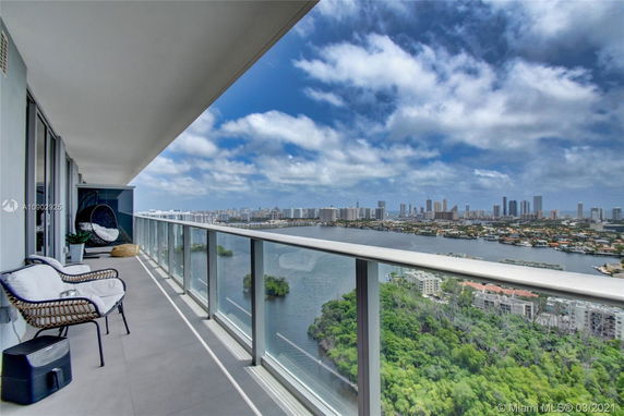 Panoramic view from a high-rise balcony overlooking a cityscape with a river.