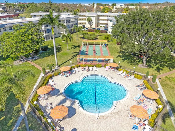 Aerial view of residential buildings with a swimming pool and outdoor recreational area.