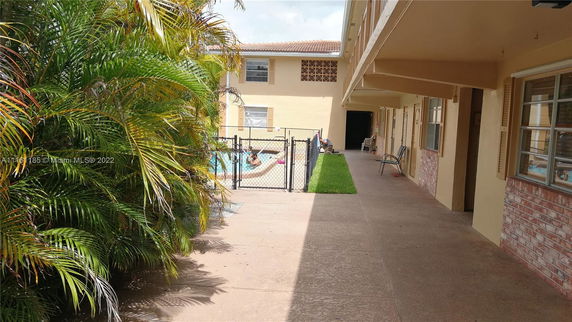 Outdoor swimming pool area fenced within an apartment complex.