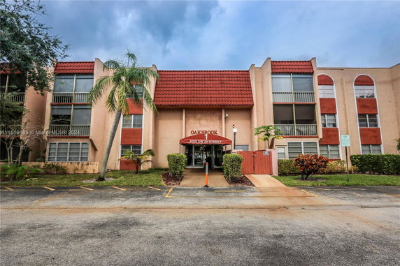 Front view of a multi-story building with red roof tiles and large windows.