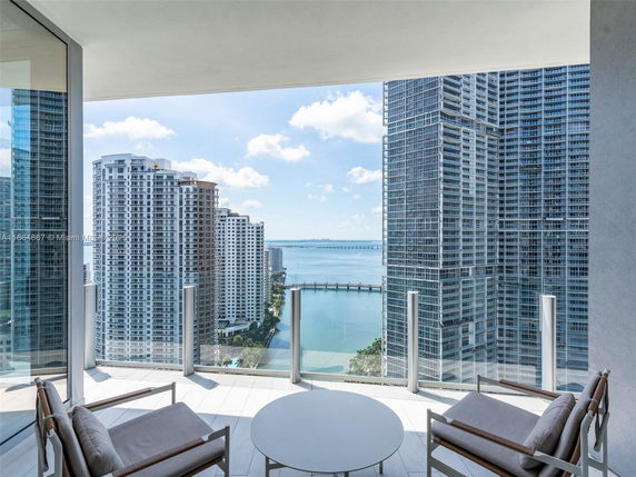 Panoramic view from a high-rise balcony overlooking the city skyline and waterfront.