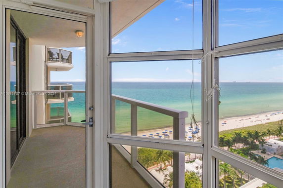 View of beach and ocean from a high-rise balcony.