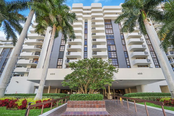Front view of a multi-story building with prominent balconies and entrance.
